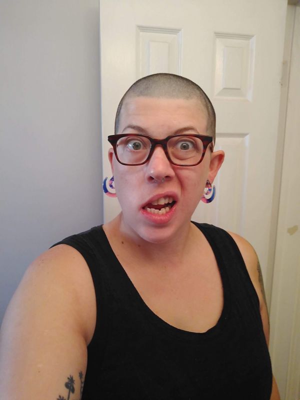 A selfie of a person making a silly face. They're wearing glasses and have a shaved head.
